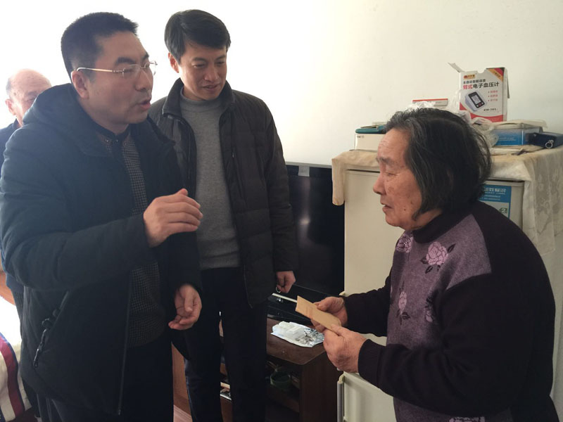 丹東市委政法委副書(shū)記、市綜治辦主任劉豐友（左一）慰問(wèn)見(jiàn)義勇為勇士周景濤的母親