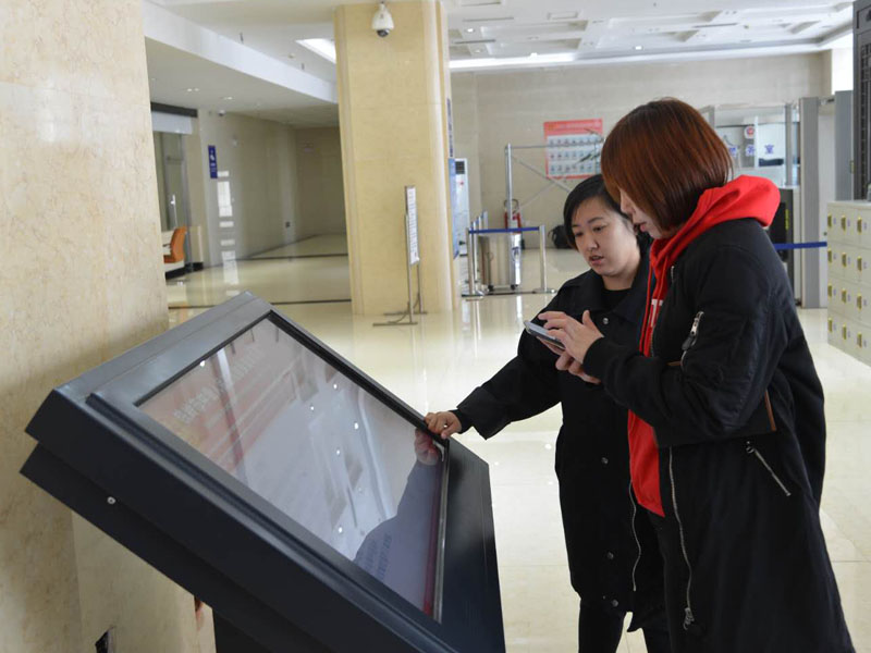 圖三，赫媛媛向記者介紹自助查詢機