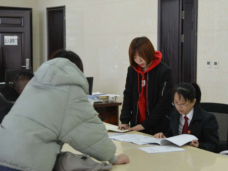 圖四，記者和劉璐一起在立案窗口接待辦事人