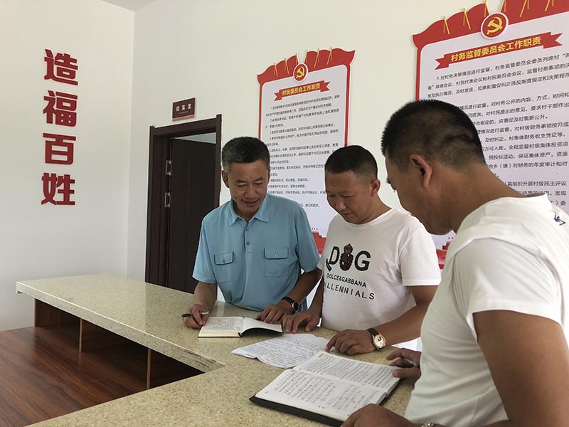 記者采訪當(dāng)天，王洪明（左一）正在和大安口村黨總支書(shū)記、村主任研究村里的新致富產(chǎn)業(yè)