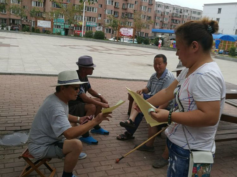 社區(qū)工作人員向居民發(fā)放宣傳單