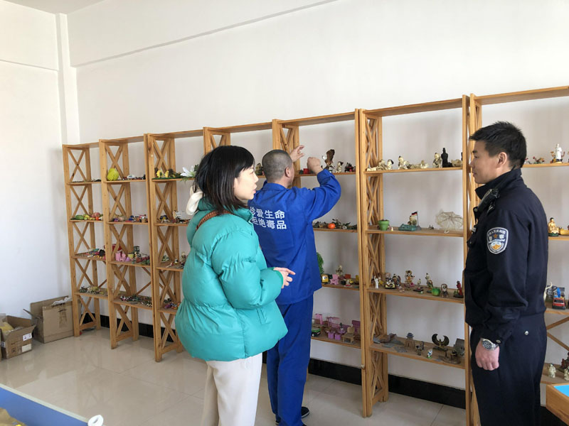 記者(左)與戒毒干警張鵬在沙盤(pán)治療室陪同戒毒學(xué)員張某選擇沙盤(pán)物品