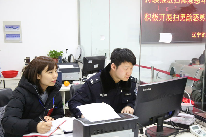 記者（左）與干警趙維佳一起為服刑人員親屬辦理會(huì)見登記