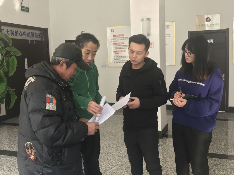 記者（右一）同中心工作人員為來(lái)申請(qǐng)法律援助的市民進(jìn)行服務(wù)