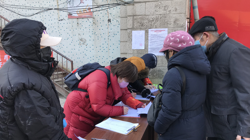 值守干部在為出入小區(qū)人員登記