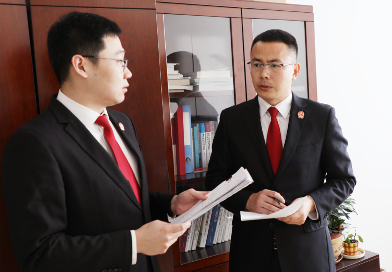 a鐵嶺市中級人民法院執(zhí)行指揮中心主任應琦（右）與同事討論案件