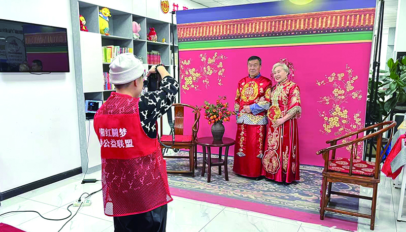 攝影師為一對(duì)老年夫婦拍攝中式婚紗照