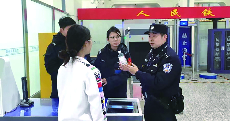 二題圖，童秋華（右）在向旅客講解安檢規(guī)定