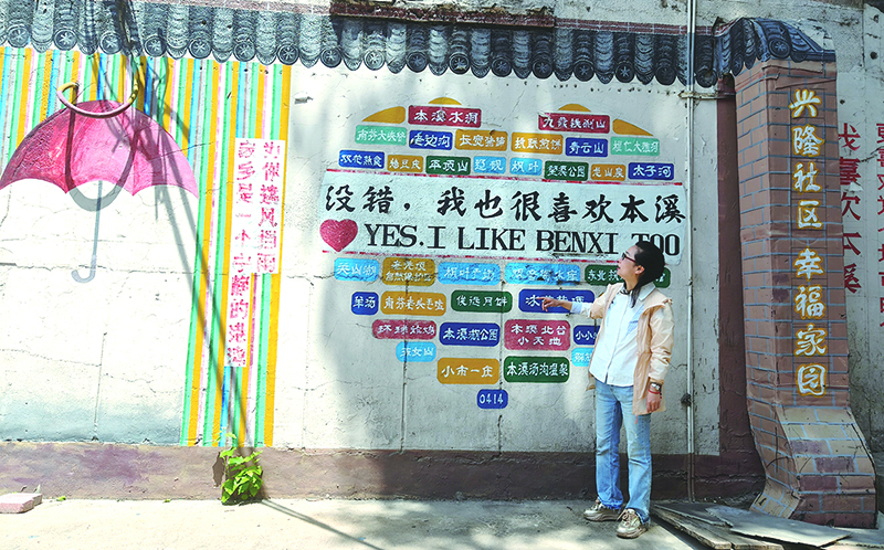 楊軼達(dá)向記者介紹社區(qū)的墻繪。