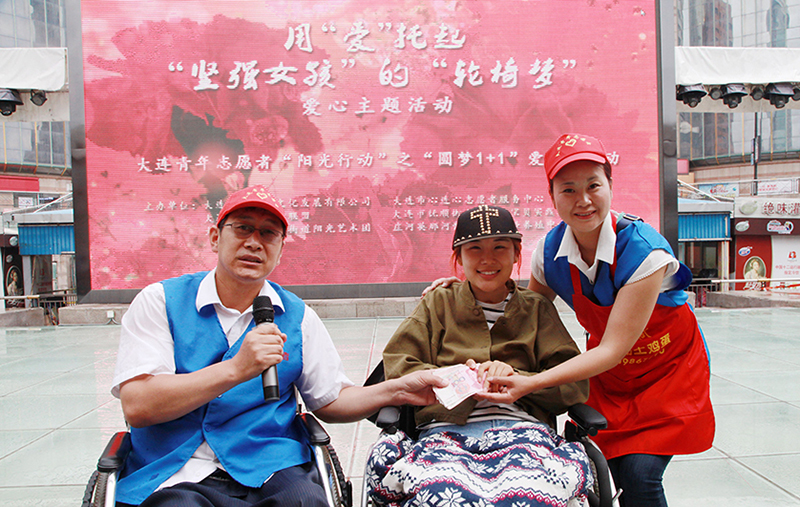 韓偉（左一）與愛人陶陸幫助重度殘疾人實現(xiàn)“輪椅夢”愛心愿望
