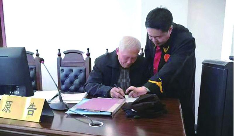 呂晉鋒（右一）指導(dǎo)當(dāng)事人填寫法律文書