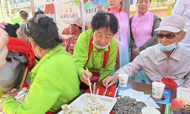 5圖，志愿者為老人包餃子歡度節(jié)日