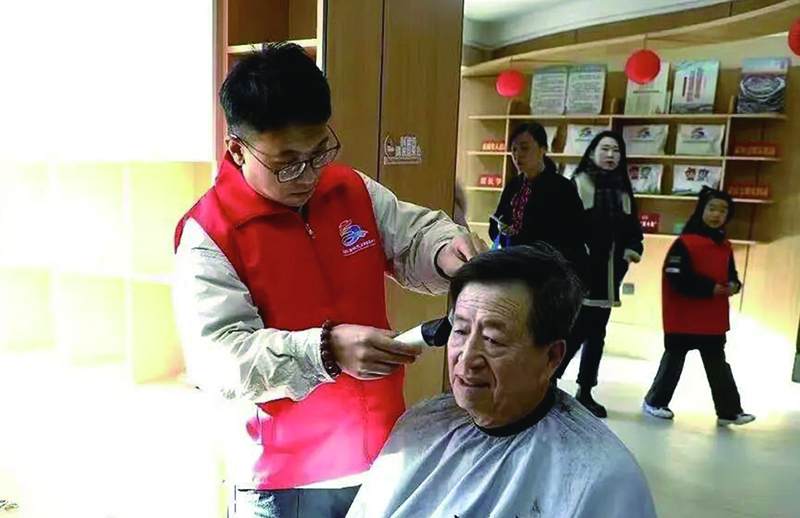 3美發(fā)師志愿者小王正在為獨居老人張大爺理發(fā)。