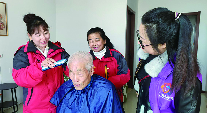 二題圖，專業(yè)社工帶領(lǐng)志愿者們上門為居民義剪