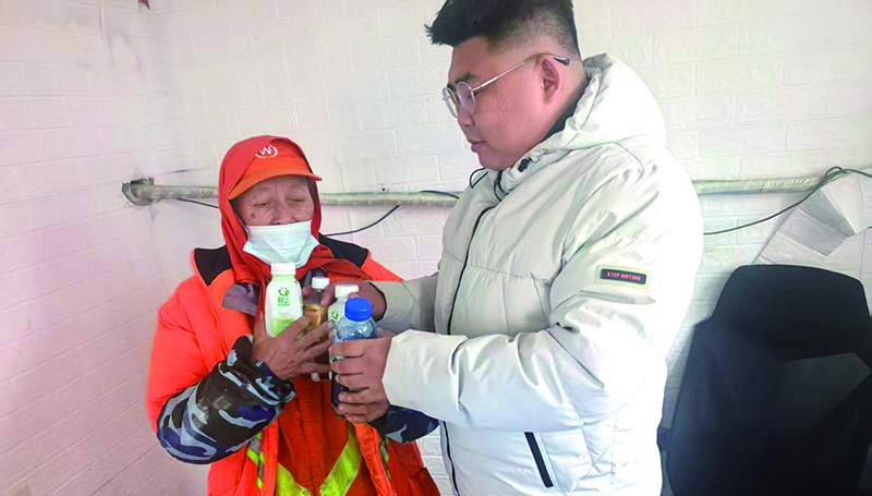 孫志強(qiáng)(右一)將廢品整理后交給環(huán)衛(wèi)工人