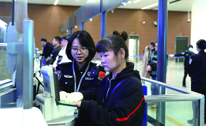 遼寧沈陽邊檢站移民管理警察幫助旅客錄入指紋。