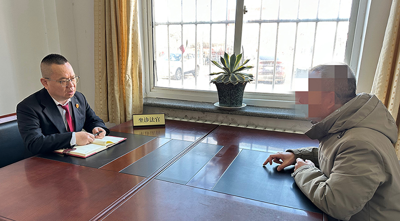 趙建峰（左一）在“法律診室”為前來(lái)咨詢的群眾解答法律問(wèn)題。